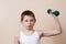 Strong little boy looking at camera while exercising with dumbb