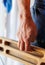 strong male hand of a rock climber holds a board for training finger strength.