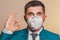 Strong man, businessman in tie and medical mask demonstrates confidence at work in pandemic coronavirus. Shows confidence and calm