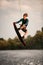 strong man masterfully jumping over river water on wakeboard.