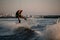 strong man masterfully jumping on splashing wave on a wakeboard