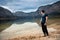 Strong man standing and relaxing near mountain lake