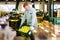 strong man working on fruit sorting line, carrying box with apples in storage