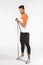 Strong masculine handsome sportsman in football activewear, standing full-length perform workout exercise with equipment