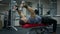 Strong masculine sportsman lying on exercise bench lifting dumbbells. Concentrated Caucasian brunette man working out in