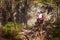 Strong mother carries her daughter on her back on a hiking trail