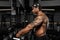 Strong and muscular dark skin man trains on modern equipment in gym. Portrait of muscular pumped up fitness trainer