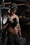 Strong and muscular dark skin man trains on modern equipment in gym. Portrait of muscular pumped up fitness trainer