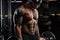 Strong and muscular dark skin man trains on modern equipment in gym. Portrait of muscular pumped up fitness trainer