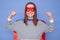 Strong powerful Caucasian brown haired woman wearing superhero costume and striped shirt isolated over blue background raised her