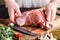 Strong professional man`s hands cutting raw lamb meat, selective focus, close-up