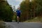 Strong retired sportsman running fast among pine forest road