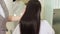 Strong, shiny and healthy long brunette hair in hands of stylist.