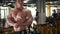 Strong shirtless bodybuilder with naked muscular torso in workout room