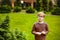 Strong, smart and funny little boy playing outdoors, wearing eyeglasses