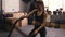 Strong sportive brunette girl in her 20`s performing battle ropes workout at the gym.
