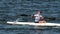 Strong sportsman rows small canoe with paddle along river