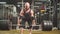 Strong sporty bodybuilder keeping heavy metal barbell in hands doing lifting exercise