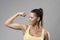 Strong sporty fit woman in yellow tank top flexing bicep muscle