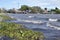 Strong stormy Winds and high tides cause lake water to rise driving water. Hyacinths and debris reaching shanty houses along the s