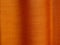 Strong sunshine filtering through woven textile textured orange color curtain drapery