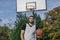 Strong and tall urban basketball player with his back to the basket on an outdoor court