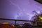 Strong thunder-storm above night mountains and city. Large Bright Lightning Close up. Mediterranian winter night