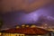 Strong thunder-storm above night mountains and city. Large Bright Lightning Close up. Mediterranian winter night