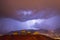 Strong thunder-storm above night mountains and city. Large Bright Lightning Close up. Mediterranian winter night