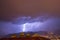 Strong thunder-storm above night mountains and city. Large Bright Lightning Close up. Mediterranian winter night