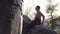 Strong topless climber rubbing his hands with chalk