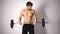 Strong topless man doing exercise with dumbbells