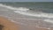 Strong waves with foam on the shore of the Sea of Azov, Ukraine. People swim in the sea