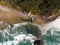 Strong waves of the ocean or sea with a rock in the water, rocky beach top view