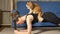 Strong woman does plank exercise while red cat sits on back