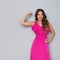 Strong Woman In Elegant Pink Dress Is Flexing Muscles And Smiling