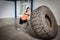 Strong woman flipping a big tire