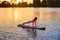 Strong woman standing in plank position on sup board