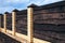 Strong wooden fence with brick posts Horizontal boards are tightly nailed to each other and provide reliable protection from