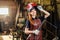 Strong and worthy pretty redhead ginher woman wearing protection helmet and leather apron with gloves holding welding