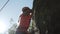 Strong young girl climbing rock trying hard. Sports outdoors in summer.