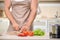 Strong young man chops vegetables in kitchen