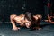 Strong young toned muscular fitness man push ups workout training on the gym floor