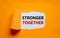 Stronger together symbol. Words Stronger together appearing behind torn orange paper. Business, motivational and Stronger together