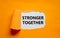 Stronger together symbol. Words Stronger together appearing behind torn orange paper. Business, motivational and Stronger together