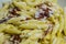 Strozzapreti cream and speck, specialty from northern Italy, fresh twisted pasta with sauce made of fresh cream and speck, closeup
