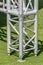 Structural detail of a lighting post base on green grass.