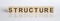 Structure word from wooden blocks on white desk