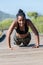 Struggling afro american woman doing push ups on a wooden runway: Exercise and effort concept.