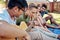 Strumming away during summer. a young man playing guitar while enjoying a few drinks with his friends outside in the